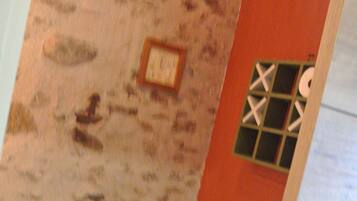 Ein Badezimmer mit Steinwand, Toilette und Duschbereich.