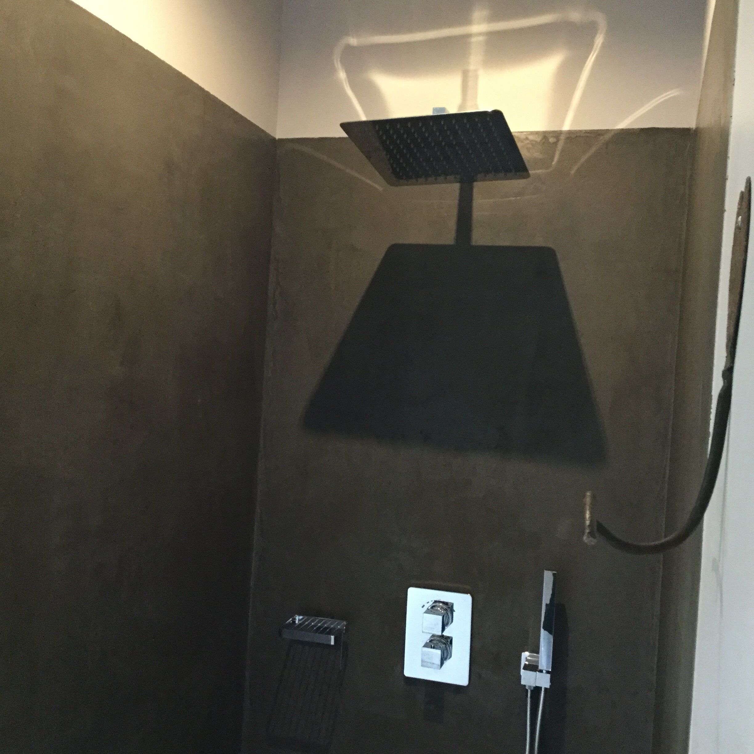 A shower with a square head, a control panel, and a hose.
