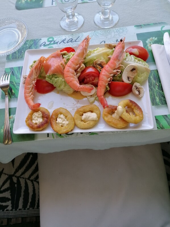 A seafood platter with shrimp, lettuce, tomatoes, and mushrooms on a white plate. - Les Hauts de Corneilhan (Corneilhan)