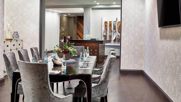 Un comedor moderno con una mesa larga, sillas grises tapizadas y un centro decorativo.