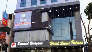 Un hôtel à plusieurs étages, doté d’une façade moderne, d’un restaurant bien visible et de plusieurs motos garées devant.