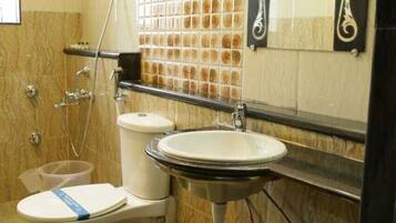 A bathroom with a toilet, sink, shower, and tiled walls.