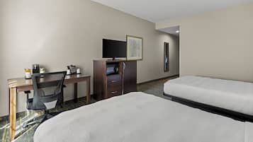 A hotel room with a bed, a desk with a chair, a television, a coffee maker, and a microwave.