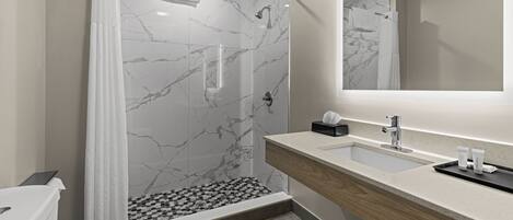 Un baño moderno con ducha, inodoro y lavamanos.