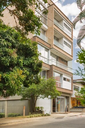 Un edificio de varios pisos con fachada de ladrillo, ventanas grandes y balcones.