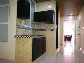Una cocina con gabinetes negros, salpicadero de azulejos y techo de madera.