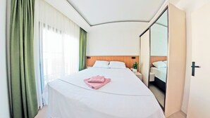A hotel room with a large bed, a nightstand, a mirror, and a sliding door to a bathroom. - Derin Apart Hotel Bodrum (Bodrum)
