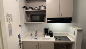 A compact kitchenette with a microwave, toaster, sink, and a small trash bin. - Studio 6 Extended Stay - Richmond, VA - I-64 West (Richmond)