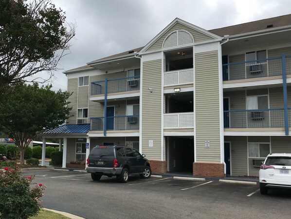 A multi-story building with a parking lot in front.