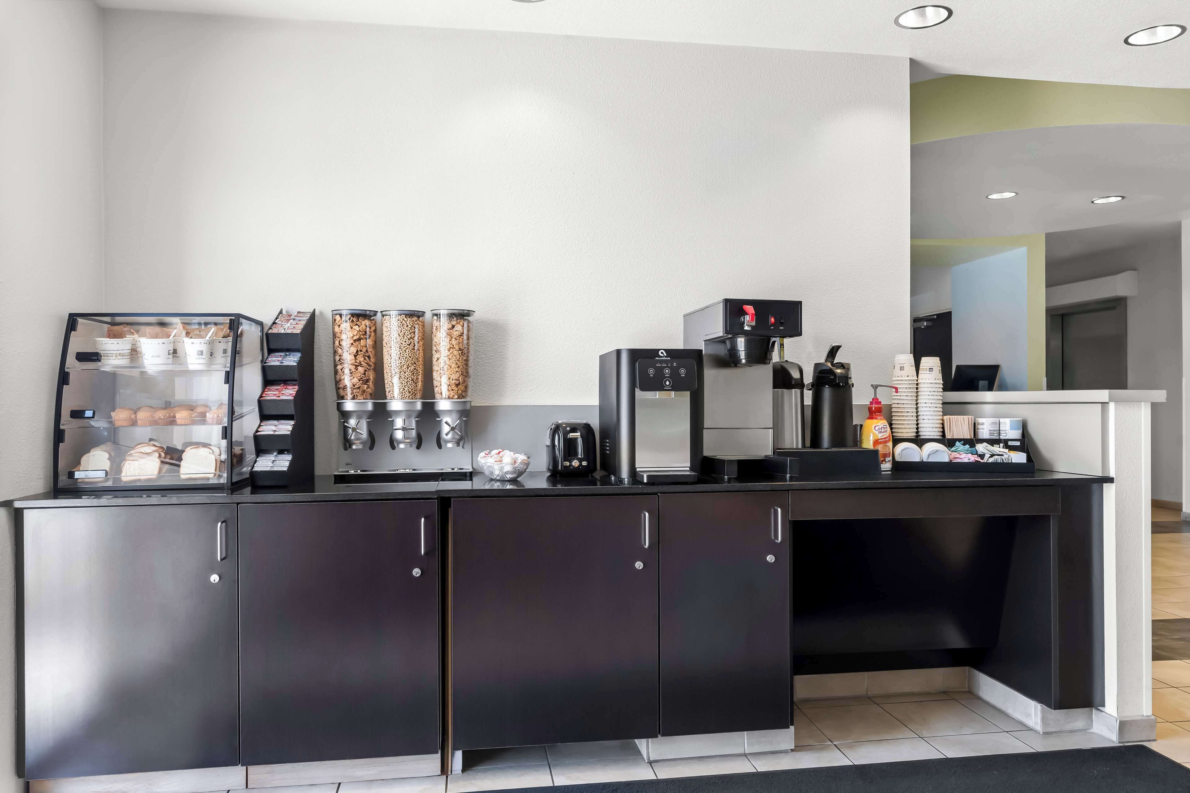 A modern kitchen area with a coffee station, including a coffee machine, a toaster, and a kettle.