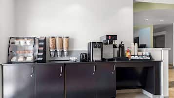 A modern kitchen area with a coffee station, including a coffee machine, a toaster, and a kettle.