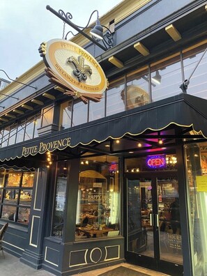 A storefront with a sign reading "PETITE PROVENCE Boulangerie & Patisserie" and "HAPPY HOUR" from Monday to Friday. - Peaceful Oasis Long-Term Stays 30+ Days Only Alberta Arts  Super Clean & Cozy  (Portland)