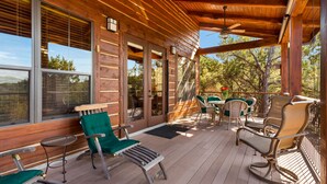 A wooden deck with outdoor furniture, including chairs and a table. - Scenic Luxury Home - Hollows Resort & Marina, Lake Travis, 4 Pools (Jonestown)