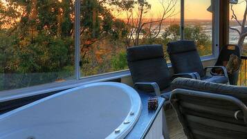 Un balcon doté d’un jacuzzi, de sièges et d’un poêle à bois.