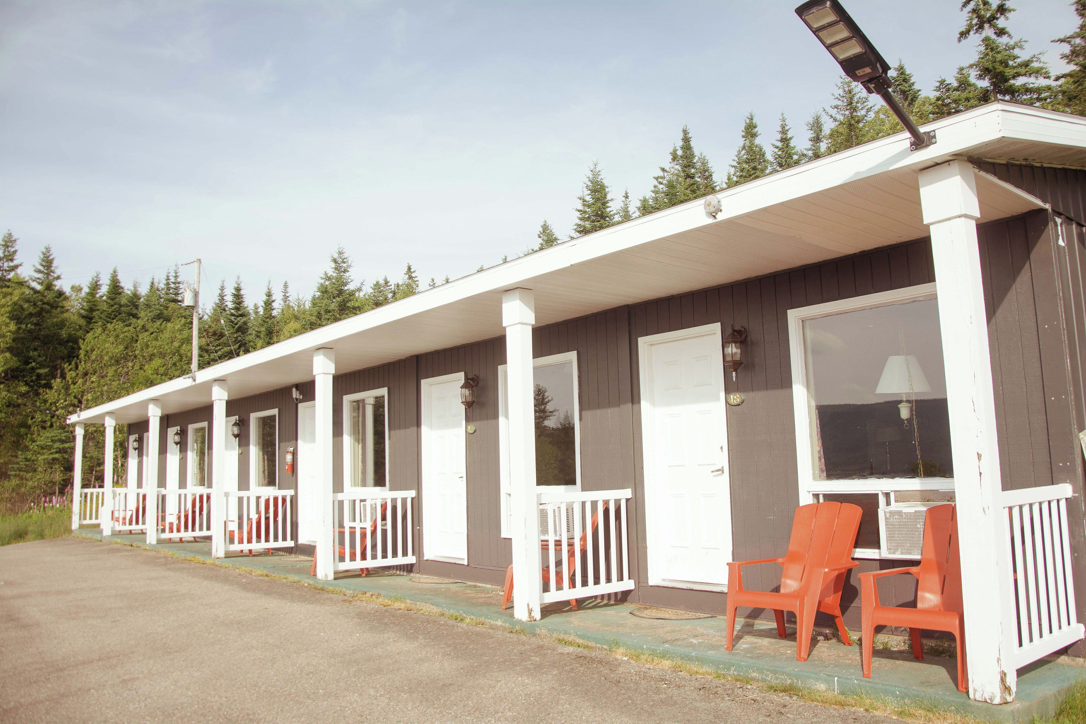 A row of cabins with white railings and a covered porch area.