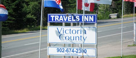 Une enseigne indiquant l’emplacement du « Travels Inn Victoria County », avec un numéro de téléphone et une mention indiquant la proximité d’un terminal de traversier.