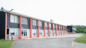A motel with a row of rooms, each with a door and window, and a small porch area.