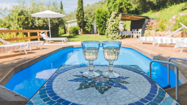 A poolside area with a mosaic table, lounge chairs, and a pergola. - Beautiful house with swimming pool surrounded by greenery, modern, luxury finishes (Camaiore)