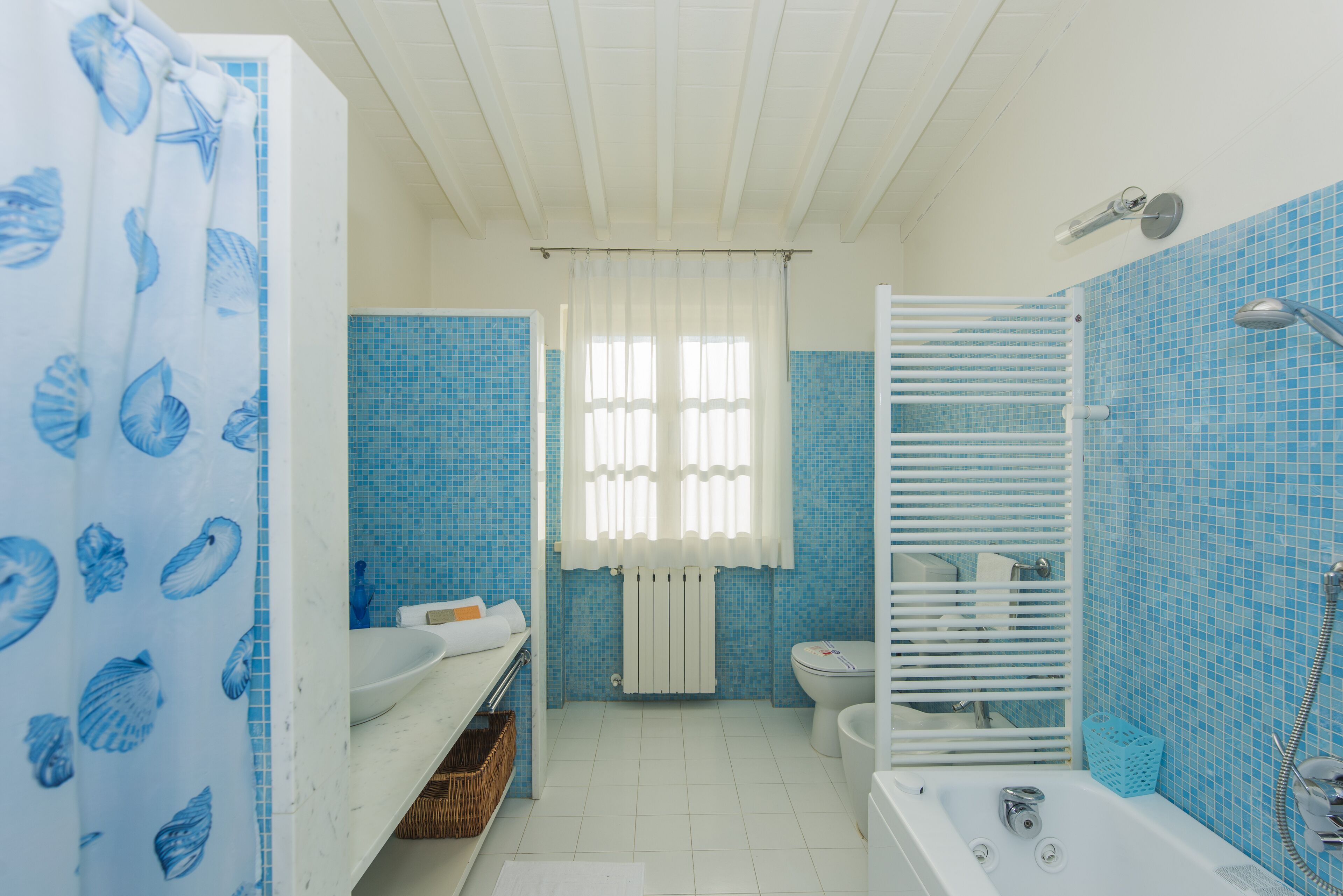 Een badkamer met een bad, toilet en douche.