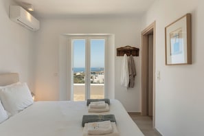 Une chambre avec un lit, une vue à travers une porte et un porte-serviettes.