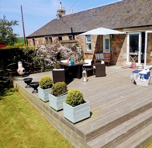 A patio with outdoor furniture, a table, and planters. - In the heart of the East Neuk, with fabulous sea view and close to great golf. (St. Monans, Fife)