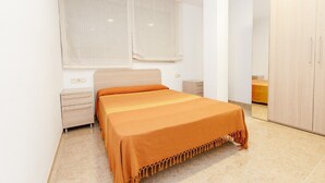 A bedroom with a bed, a nightstand, a wardrobe, and a window with curtains. - Hermitage 1stA (Peñiscola)