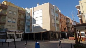 A modern building with a flat facade, large windows, and a ground-level entrance. - Hermitage 1stA (Peñiscola)