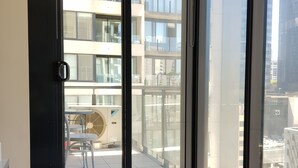 Ein modernes Zimmer mit großen Fenstern, einem Glastisch und Topfpflanzen.