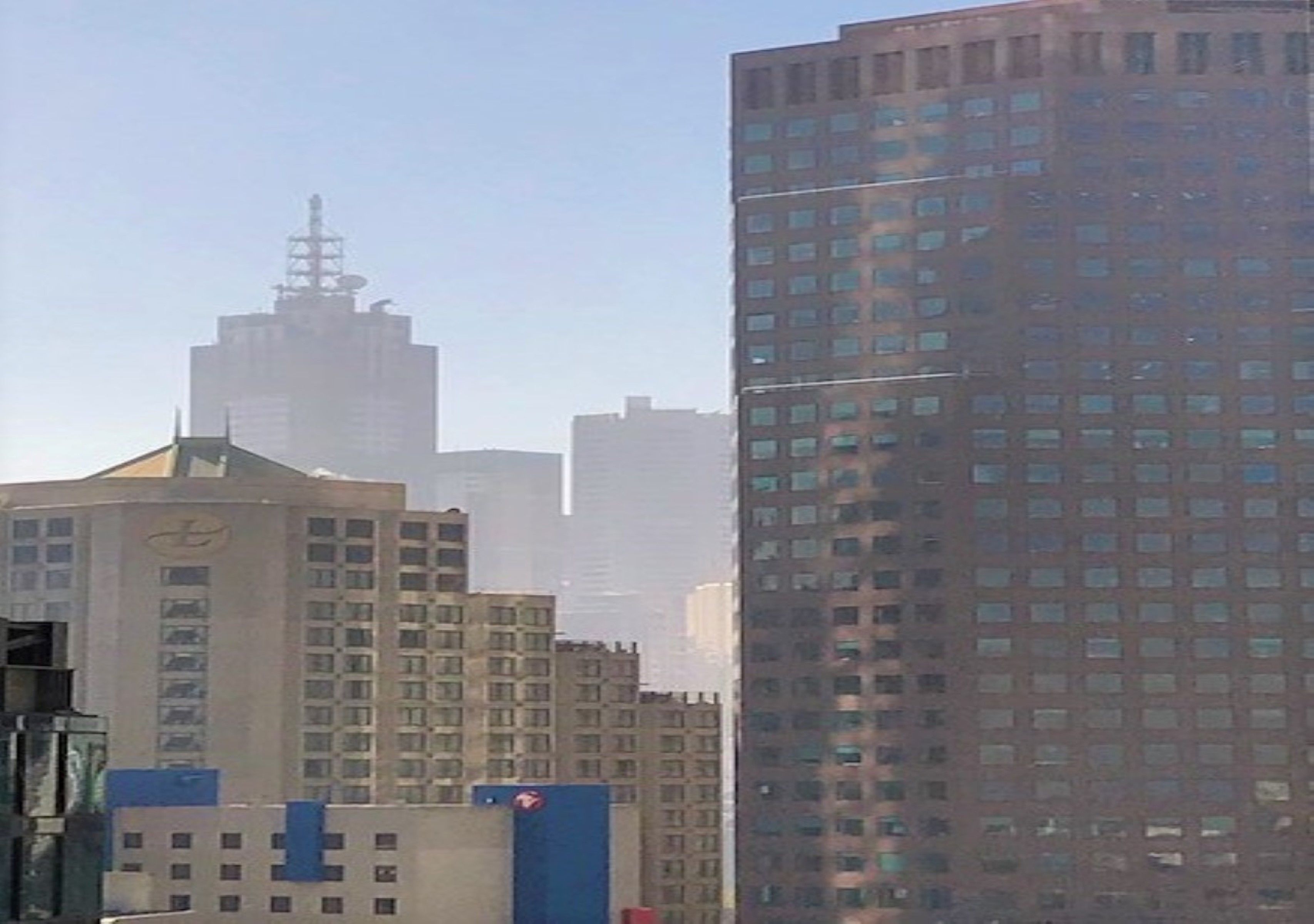 Un edificio de gran altura con una destacada torre de reloj y una fachada de vidrio moderna.