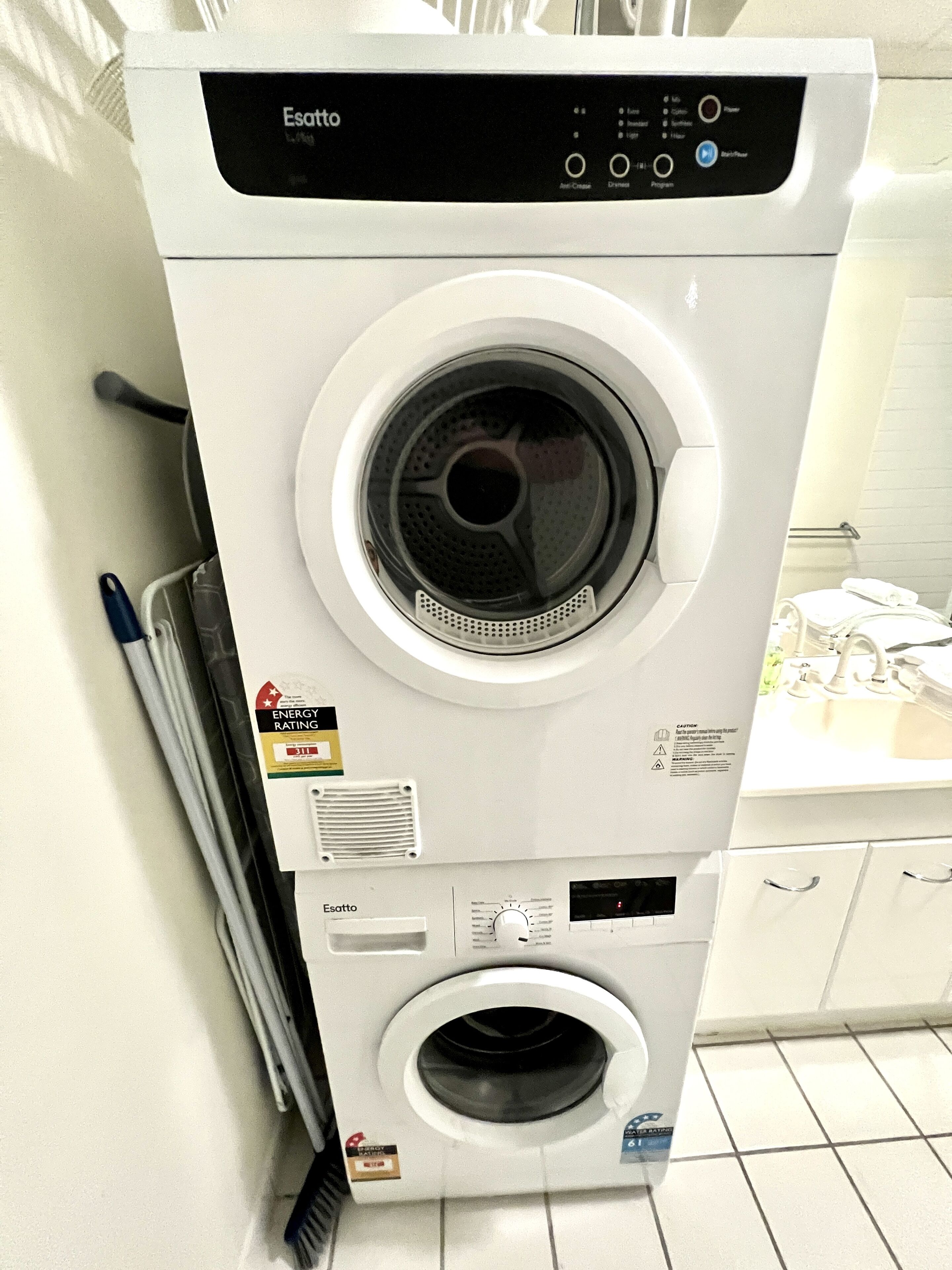 A front-loading Esatto washing machine with a digital display, energy rating label, and a control panel with various settings.
