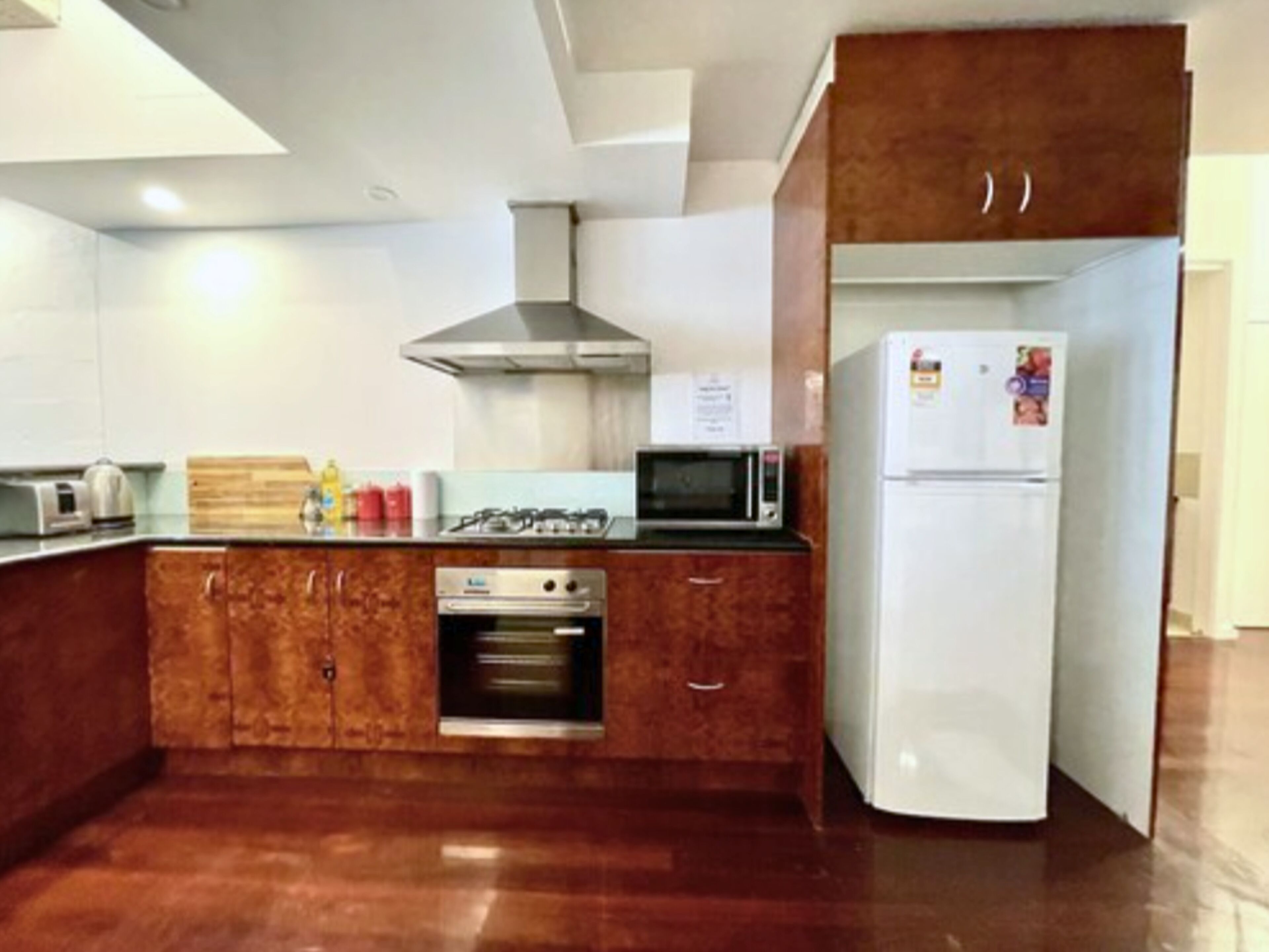 Eine Küche mit Gasherd, Mikrowelle, Backofen und Kühlschrank.