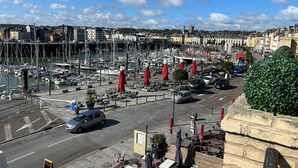 A marina with boats, a café area with tables and red umbrellas, and a cityscape in the background. - Grand Duplex ****, Sea View, 5 bedrooms, linen provided, private garden  (Hautot-Sur-Mer)