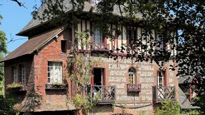 A traditional brick house with a wooden balcony, a stone wall, and a small water channel in front. - Grand Duplex ****, Sea View, 5 bedrooms, linen provided, private garden  (Hautot-Sur-Mer)