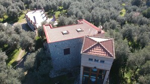 A stone building with a red-tiled roof, surrounded by dense olive trees. - POGGIO TAKUNA swimming among the olive trees... and more! !!  (Itri)