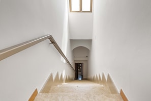 Una escalera con barandilla que lleva a una puerta en la parte superior.