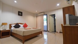 A hotel room with a bed, bedside table, lamp, air conditioning unit, and a TV. - Kyongean Mansion 2 (Krabi)