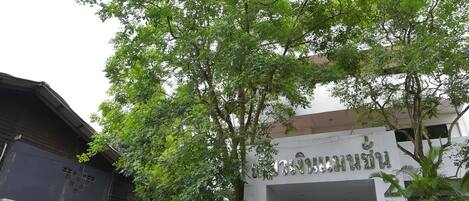 Un edificio con una escalera que conduce a la entrada, rodeado de follaje.