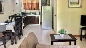 Un espacio habitable compacto con zona de comedor, kitchenette y sofá.