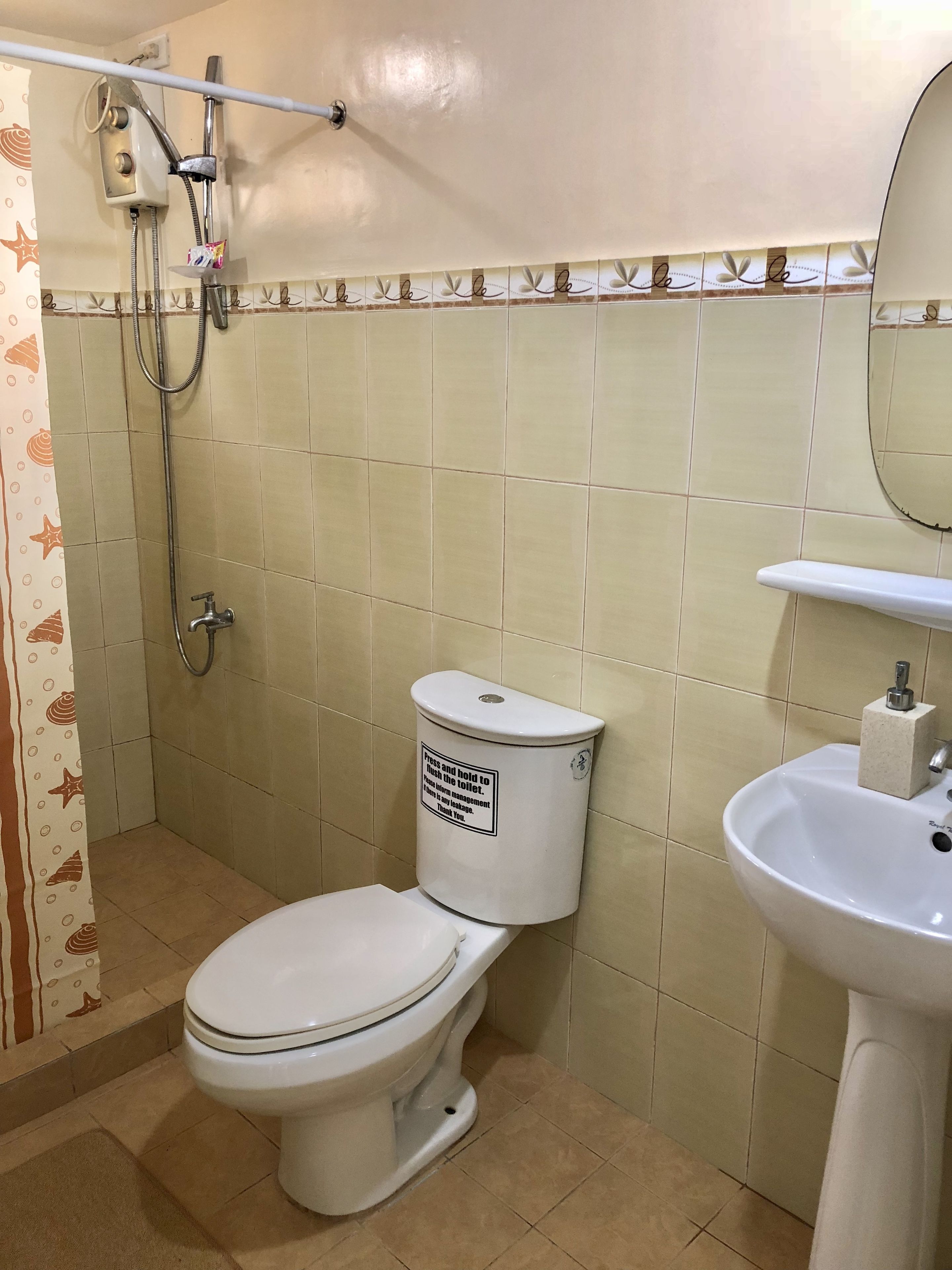 A bathroom with a toilet, a sink, and a shower.