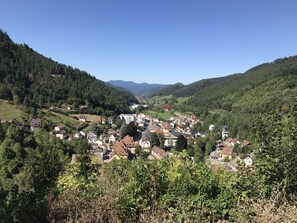 Une ville nichée dans une vallée, avec des maisons et des bâtiments entourés de collines boisées.
