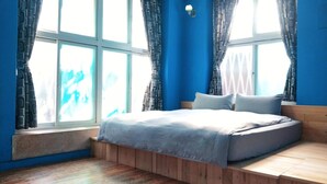 Un dormitorio con cama, ventana y banco empotrado.