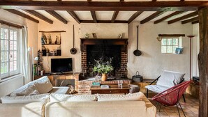 A cozy living room with a fireplace, a television, and a comfortable seating area. - Cozy home in Beauchene with WiFi (Beauchene)