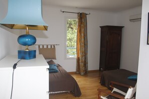 A bedroom with a bed, a desk with a lamp, a wardrobe, and a window with curtains. - Holiday farmhouse at the vineyard in the Camargue (Arles)