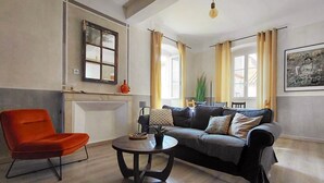 A living room with a sofa, armchair, and round table. - Casa Delia (L'Île-Rousse)