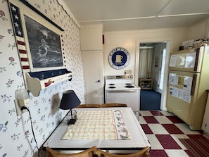 Classic kitchen with a vintage flair, featuring a stove, refrigerator, and floral wallpaper.