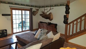 Une pièce comprenant un lit, une commode et une tête de cerf accrochée au mur.
