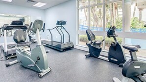 A gym with treadmills, stationary bikes, and exercise equipment.