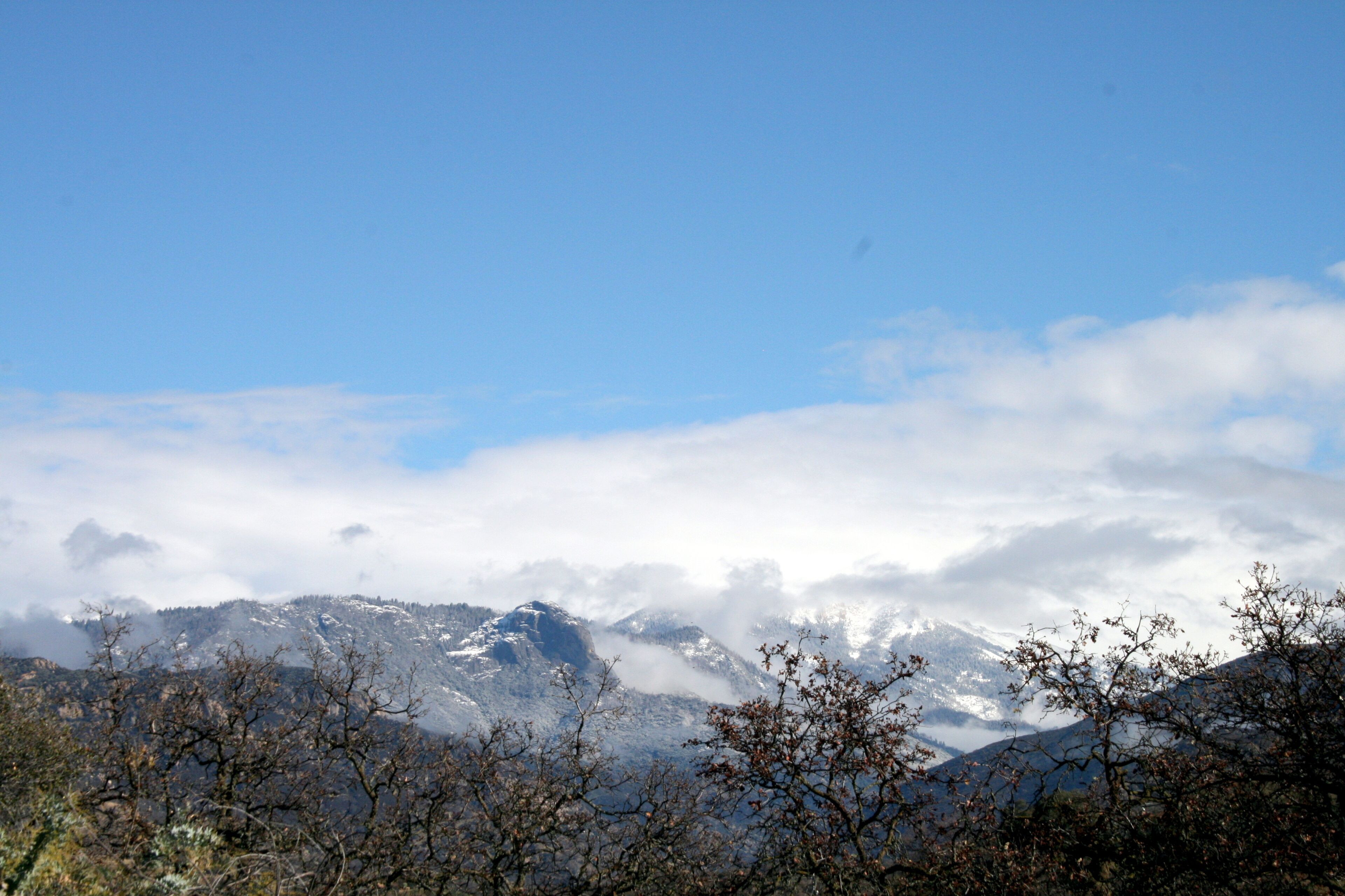 Un paisaje montañoso con picos nevados y cielo despejado.