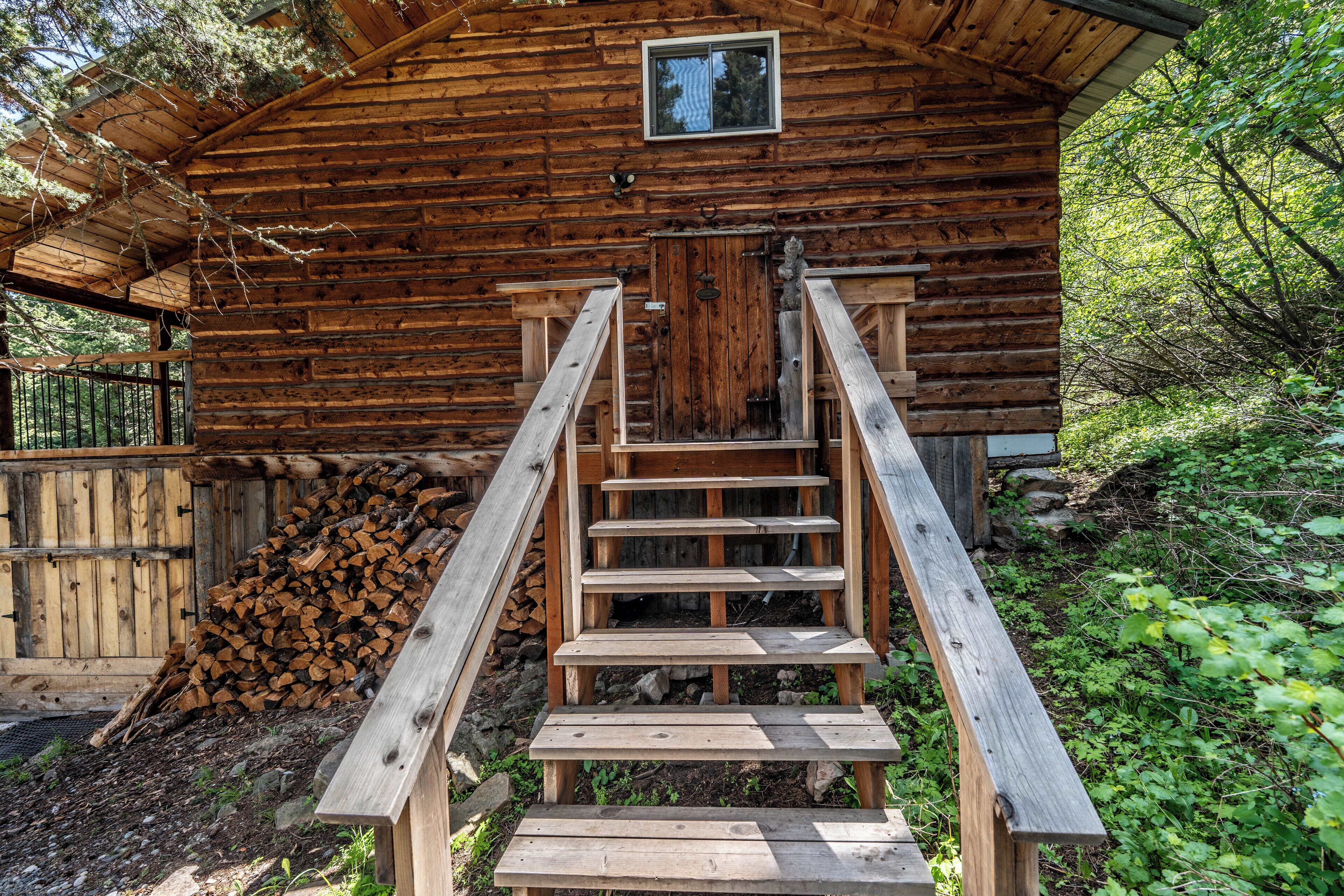 A wooden cabin with a wooden staircase leading to a door.