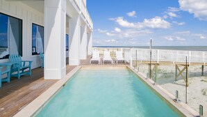 A pool area with a wooden deck, lounge chairs, and a view of the beach. - "The Pearl" GULF FRONT w/prvt heated pool, 12 bdrm /12.5bath "ALVacationRentals" (Gulf Shores)